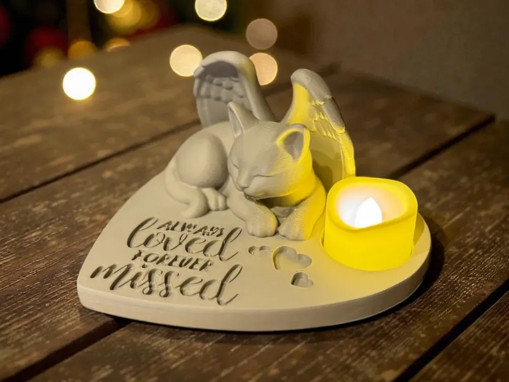 Placa em formato de coração com um gato de asas dormindo, frase em relevo e espaço para vela de LED